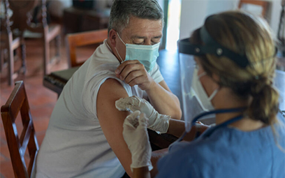 Pictured: An adult man getting a COVID19 vaccine at his rural house